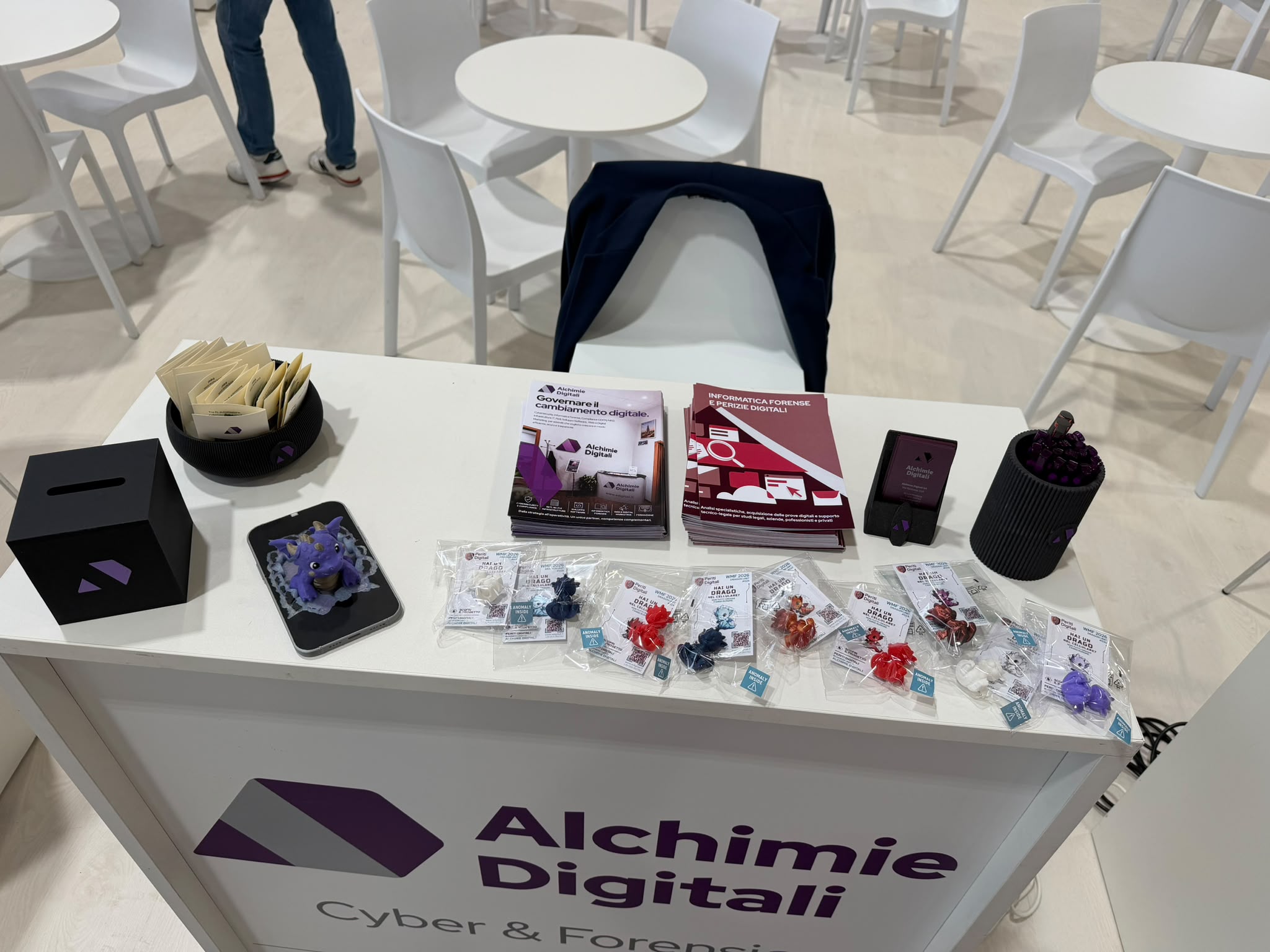 Desk Alchimie Digitali con logo, payoff Cyber & Forensics e gadget in esposizione